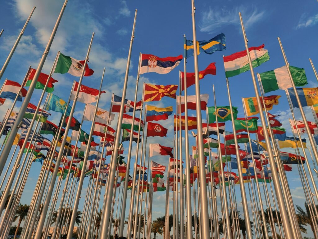 pexels photo 29303947 29303947 A diverse collection of national flags waving under a vibrant blue sky.