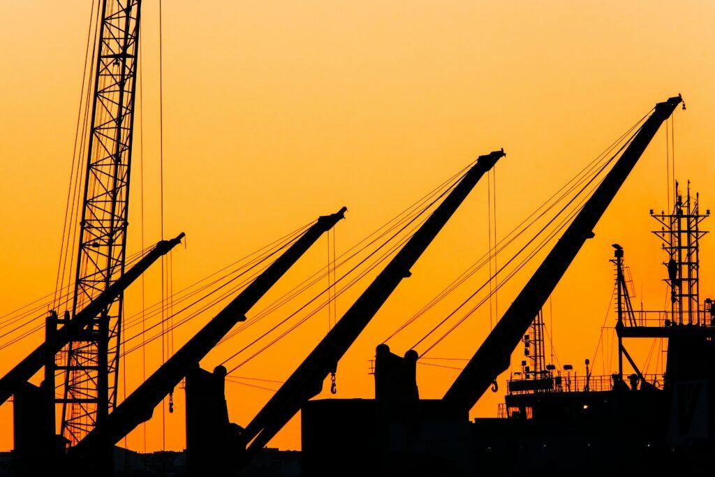 pexels photo 30278768 30278768 Silhouetted cranes and masts create a striking industrial skyline against a vibrant sunset backdrop.