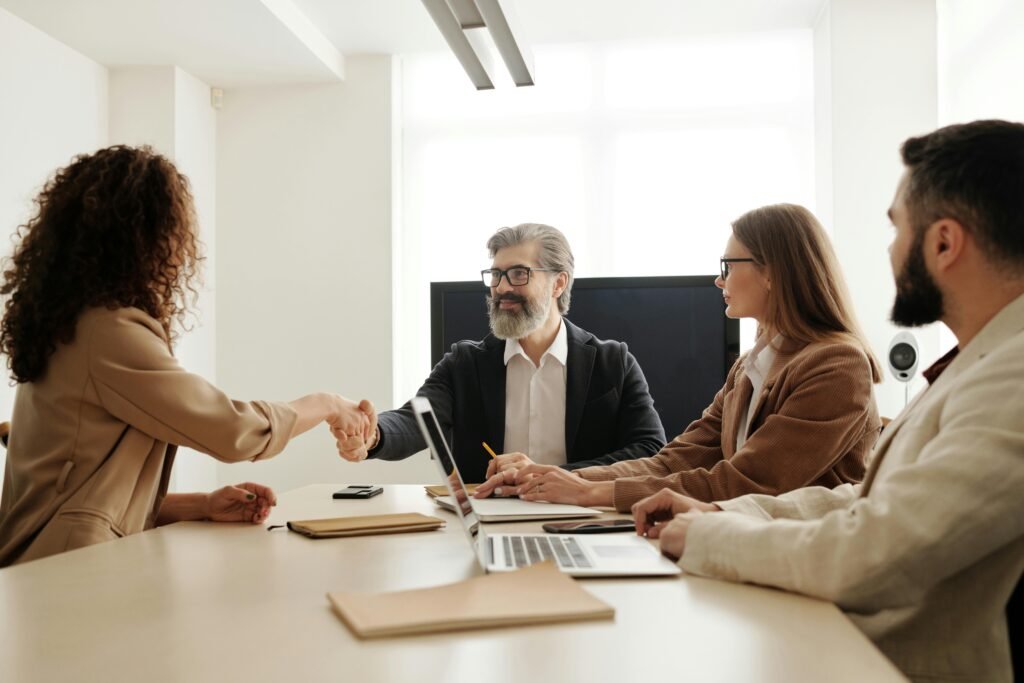 pexels photo 4344860 4344860 Colleagues in an office celebrating a successful negotiation with a handshake.