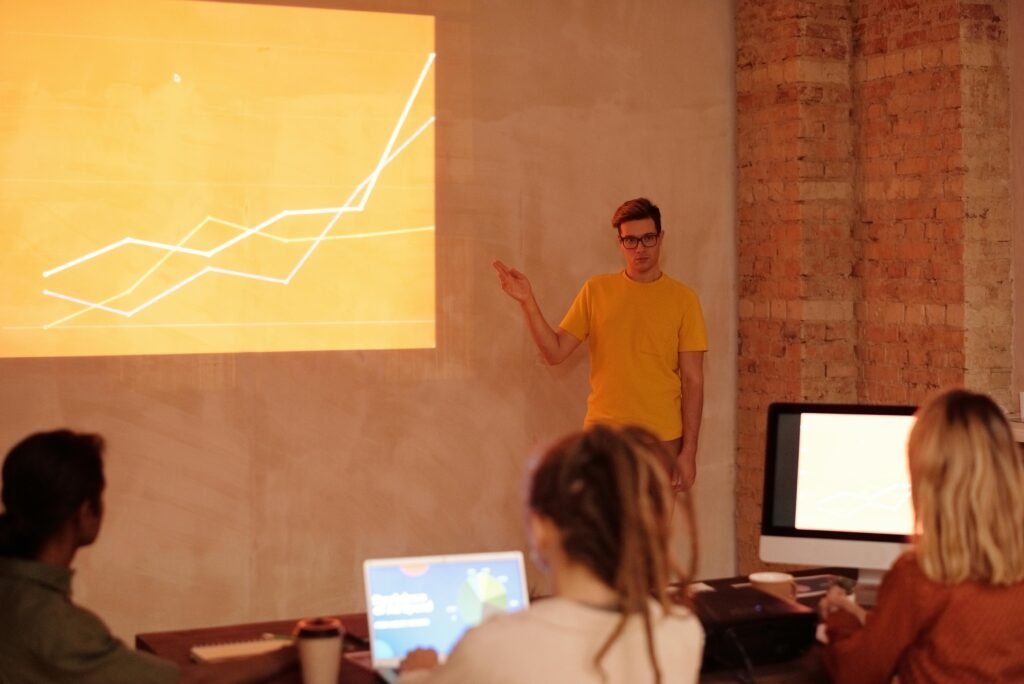 pexels photo 6476782 6476782 A young man gives a presentation on data analysis in a modern office setting.